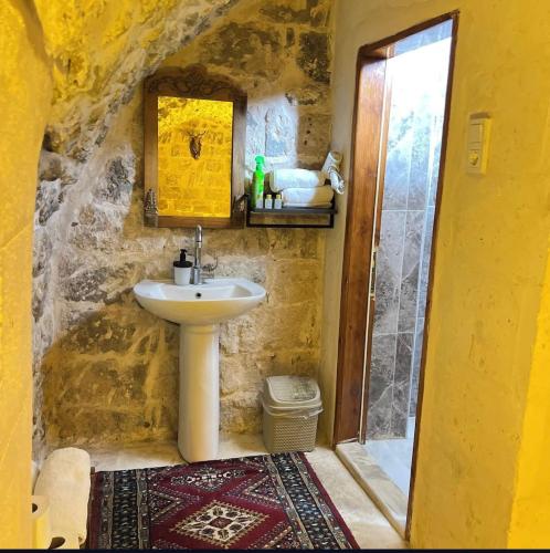 a bathroom with a sink in a stone wall at Kasr-ı Han Konağı Otel in Mardin