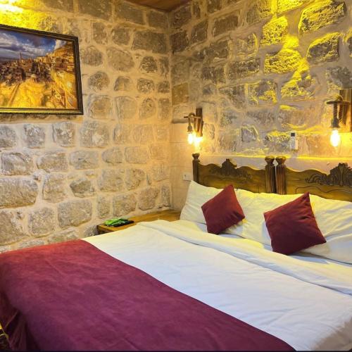 a bedroom with a bed in a stone wall at Kasr-ı Han Konağı Otel in Mardin