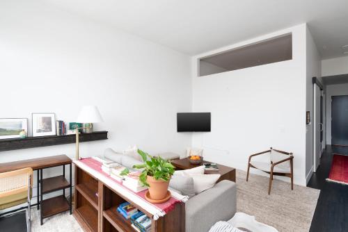 una sala de estar con un sofá y una mesa en Modern 1BR Apt with Skywalk to Fiserv, Rooftop, and Parking, en Milwaukee