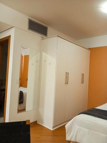 a bedroom with white cabinets and a bed at Flat completo no hotel Comfort de Alphaville in Barueri