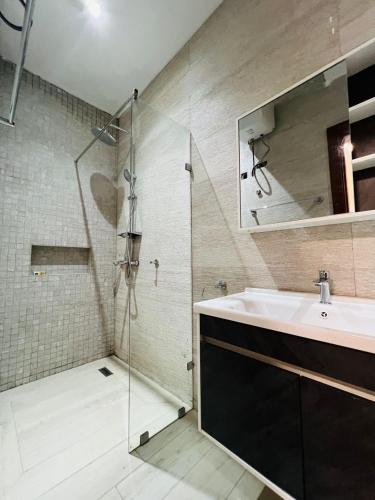 a bathroom with a sink and a glass shower at Gabika Suites in Trofwi