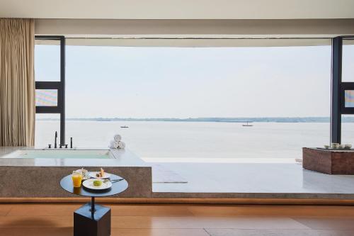 Una sala de estar con vista al agua. en Floral Luxury Wuhu Lake Art Hotel, en Wuhu