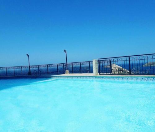 una piscina con acqua blu di fronte a una recinzione di El Peñon-Rodadero-Sunset-Cheap Building a Rodadero