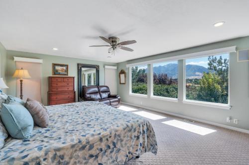 a bedroom with a bed and a chair and windows at Over The River in Kinney Estates