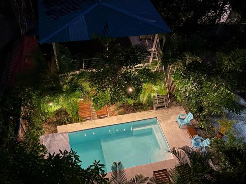 Una vista aérea de una piscina con sillas y una sombrilla. en Olas de Oro, en Nicoya
