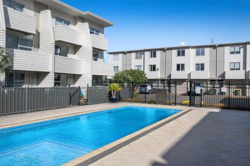 una piscina di fronte a un condominio di Right Opposite the Beach! a Orewa