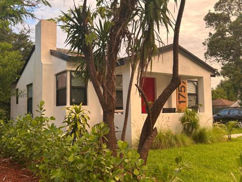 a white house with palm trees in front of it at Cozy Home away from home! in Miami