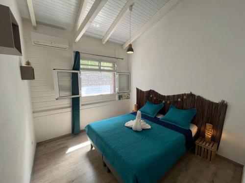 a bedroom with a bed with a stuffed animal on it at Villa F3, Eden Krys, a cocoon of tranquility in La Trinité