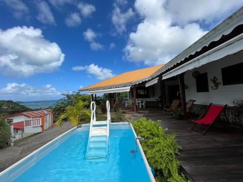 a swimming pool in front of a house at Villa F3, Eden Krys, a cocoon of tranquility in La Trinité