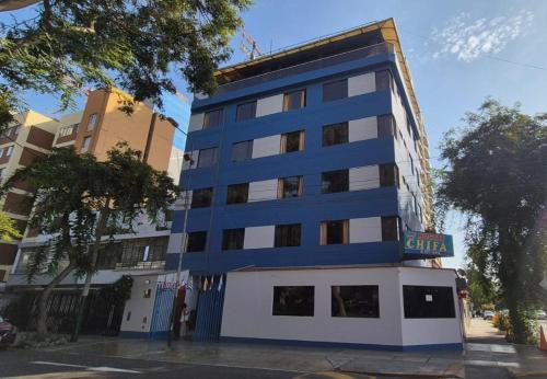 Un edificio azul y blanco en una calle de la ciudad. en Hostal Winya, en Lima