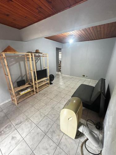 a living room with a couch and a tv at Casa em Juquehy 200m da praia in São Sebastião