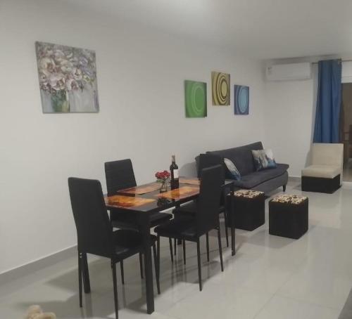 una sala da pranzo con tavolo, sedie e divano di Casa moderna en urbanización privada a Manta
