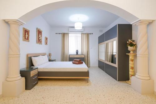 1 dormitorio con 1 cama y un arco en Gżira Well-Equipped 4BR Flat in Peaceful - GV, en Il-Gżira