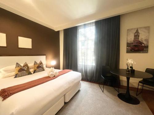 ein Schlafzimmer mit einem Bett und einem Tisch und einem Fenster in der Unterkunft Charming Studio Apartment in Auckland Central in Auckland