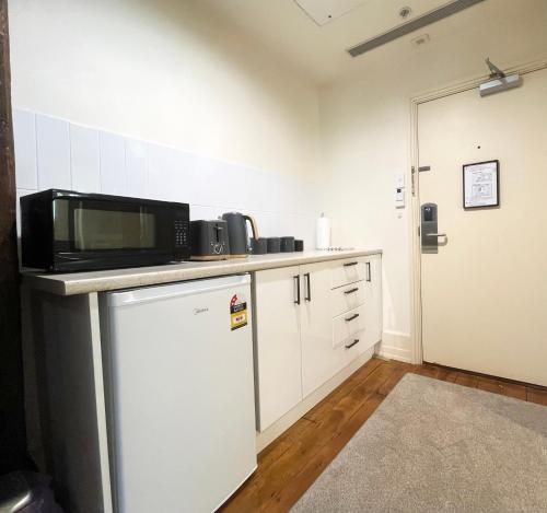 a small kitchen with a microwave on a counter at Charming Studio Apartment in Auckland Central in Auckland