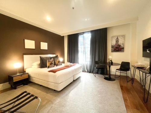 a bedroom with a bed and a desk and a window at Charming Studio Apartment in Auckland Central in Auckland