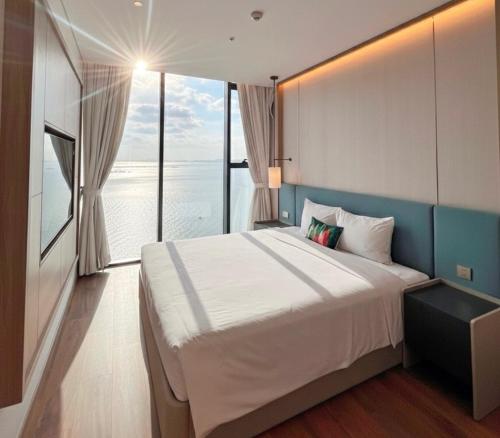 um quarto com uma cama grande e uma janela grande em A La Carte Ha Long Oceanview Panoramic 2BR2WC 75m2 Residence Suite with balcony em Ha Long