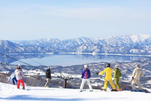 a group of people standing on a ski slope at KAMENOI HOTEL Tazawako in Senboku