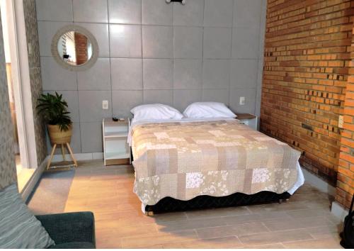 a bedroom with a bed and a brick wall at Habitación standard - SKYHOME I in Luque