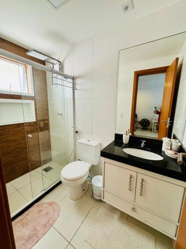 a bathroom with a toilet and a sink and a shower at Resort Praia Grande in Arraial do Cabo