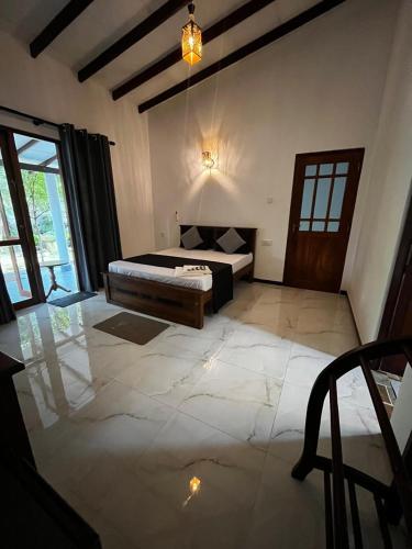 a large room with a bed and a window at Villa Amore in Ahangama
