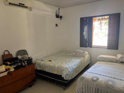 UruçucaCasa de Praia Serra Grande X Itacaré的一间卧室，配有两张床、一个梳妆台和一扇窗户