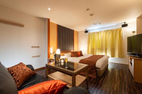 a hotel room with a bed and a couch at ホテルAO男塾ホテルグループHimeji in Himeji