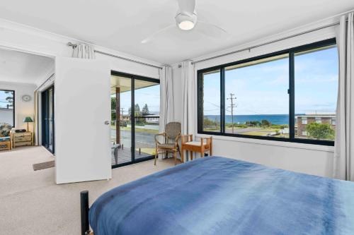 文森提亚Summer-Salt by Experience Jervis Bay的带蓝色床和大窗户的卧室