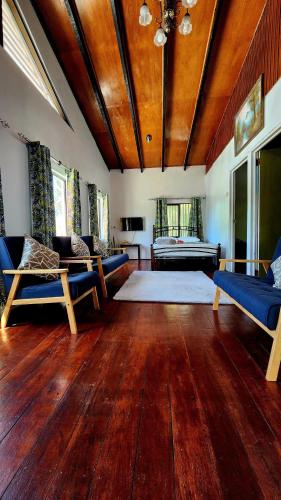 Una gran sala de estar con suelos de madera y muebles azules. en sunny's homestay, en Sigatoka