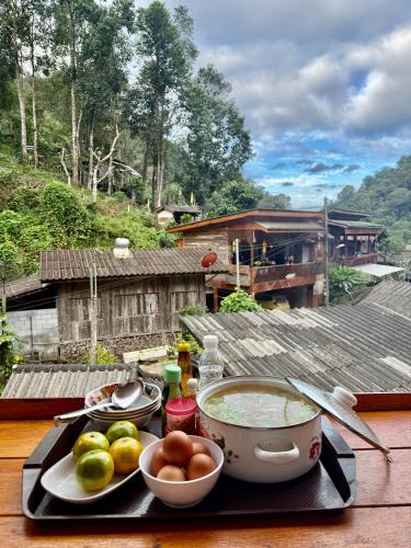 een dienblad met eten op een tafel met een fruitschaal bij กินลมชมจันทร์ แม่กำปอง in Ban Pok Nai