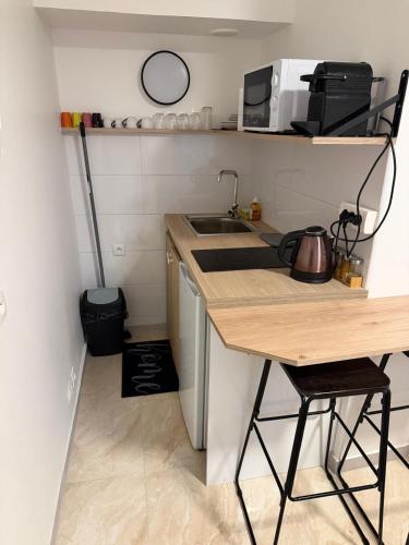 Studio Cosy في Auneau: مطبخ صغير مزود بمنضدة وحوض غسيل