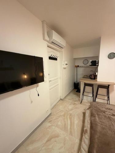 Studio Cosy في Auneau: غرفة معيشة بها تلفزيون بشاشة مسطحة كبيرة مثبت على الحائط