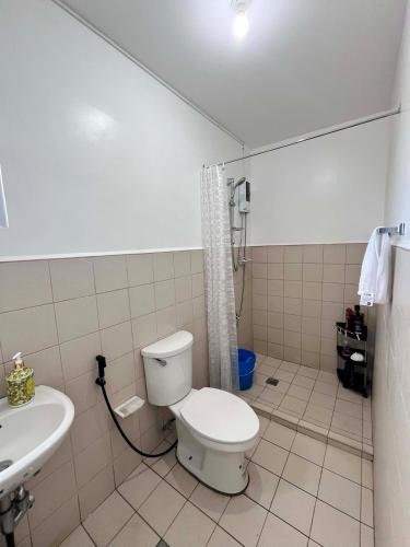 a bathroom with a toilet and a sink at Villa Amore in Dauis