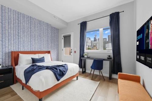 une chambre avec un lit, un bureau et une fenêtre dans l'établissement Stylish 3BR CN Tower Views & Patio Mini Putt, à Toronto