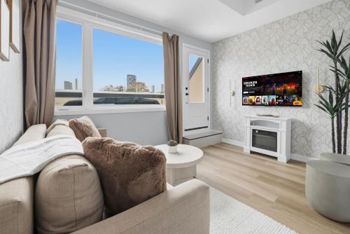 un salon avec un canapé et une télévision dans l'établissement Stylish 3BR CN Tower Views & Patio Mini Putt, à Toronto