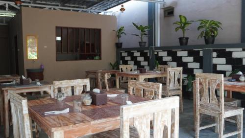 a dining room with wooden tables and chairs at Savira Golo Koe Labuan Bajo in Komodo Labuan Bajo Airport
