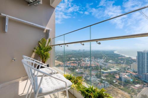 un balcon avec une chaise et une vue sur l'océan dans l'établissement CĂN HỘ THE SÓNG TAM THẮNG VŨNG TÀU - LUXURY APARTMENT Mr Tú, à Vung Tau