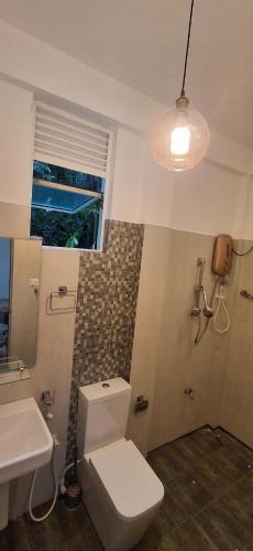 a bathroom with a white toilet and a sink at mountain retreat villa in Kandy