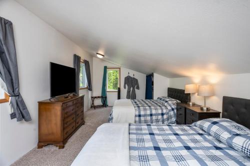 una camera da letto con due letti e una TV a schermo piatto di Cozy Lakefront Retreat a Wasilla