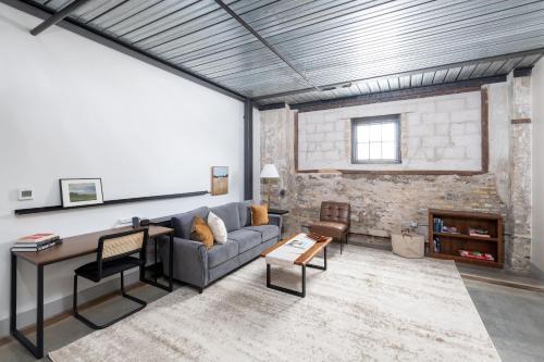 ein Wohnzimmer mit Sofa und Tisch in der Unterkunft Spacious 1BR Near Fiserv with Rooftop, Gym, and Parking in Milwaukee