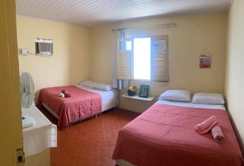 En eller flere senge i et værelse på Casa PÉ NA AREIA Paripueira