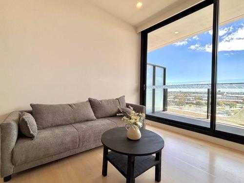 北克莱顿M-City Monash Spacious Skyline Escape & Hospital的客厅里有一张沙发和一张桌子。