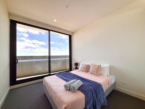 北克莱顿M-City Monash Spacious Skyline Escape & Hospital的一间卧室，里面有一张床和一扇大窗户。