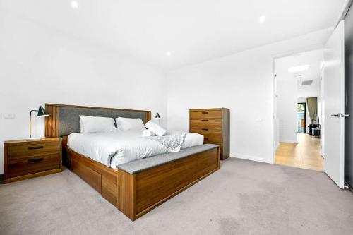 una camera da letto con un letto grande con testiera in legno di Stylish 2BR Home in Doncaster with parking a Doncaster