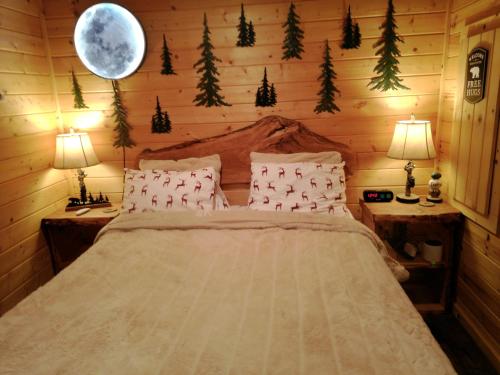um quarto com uma cama com árvores de Natal na parede em Knotty Shack- Unique Tiny Log Cabin with Hot Tub em Ashford