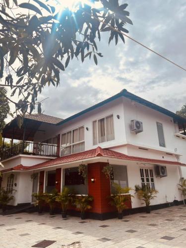 安巴拉瓦亚尔Royal homestay的白色的建筑,有蓝色的屋顶