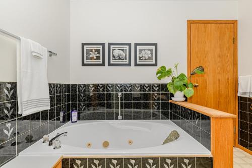 y baño con bañera y azulejos blancos y negros. en Bayview Bed and Breakfast, en Mill Bay