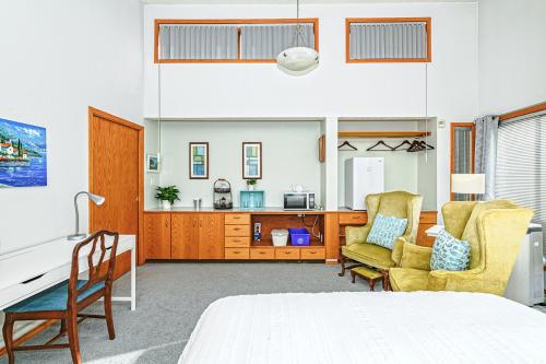 Un dormitorio con una cama y un escritorio y sillas. en Bayview Bed and Breakfast, en Mill Bay