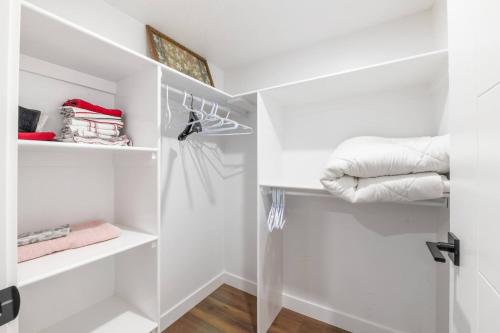 a white walk in closet with white shelves at Spacious Home • 3BR • Close to Whyte and Downtown in Edmonton