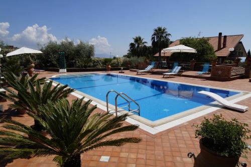 ザッフェラーナ・エトネーアにあるVilla esclusiva con piscina privata e vista Etnaの椅子とパラソルのある大きなプール